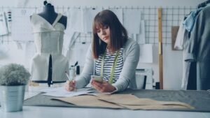 Fashion designer works diligently on sketches in a creative studio setting.