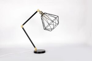 Minimalist geometric metal table lamp with adjustable design on a white backdrop.
