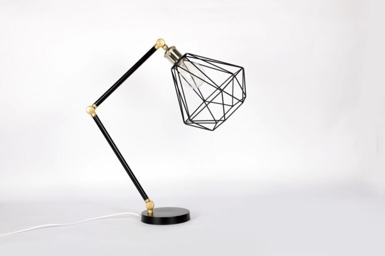 Minimalist geometric metal table lamp with adjustable design on a white backdrop.