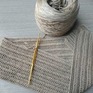 A detailed view of yarn and crochet hook, showcasing the art of needlework and craftsmanship.
